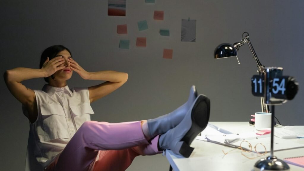 Overworked woman takes a break at her desk, showing exhaustion and relaxation