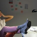Overworked woman takes a break at her desk, showing exhaustion and relaxation
