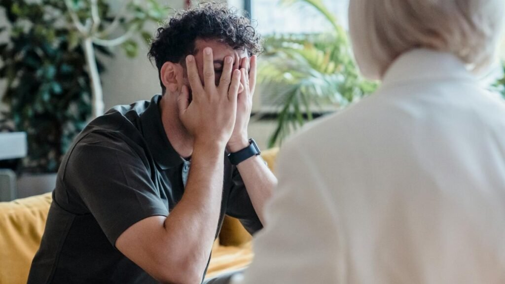 Man seeking support in therapy, expressing emotions during an indoor counseling session.