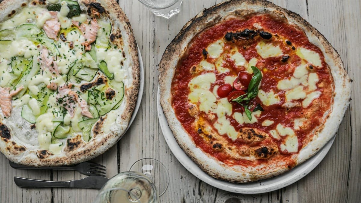 Two gourmet pizzas with unique toppings: salmon with zucchini and classic margherita.