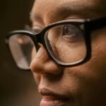 A close-up image capturing a person in a thoughtful mood, highlighting eyeglasses.