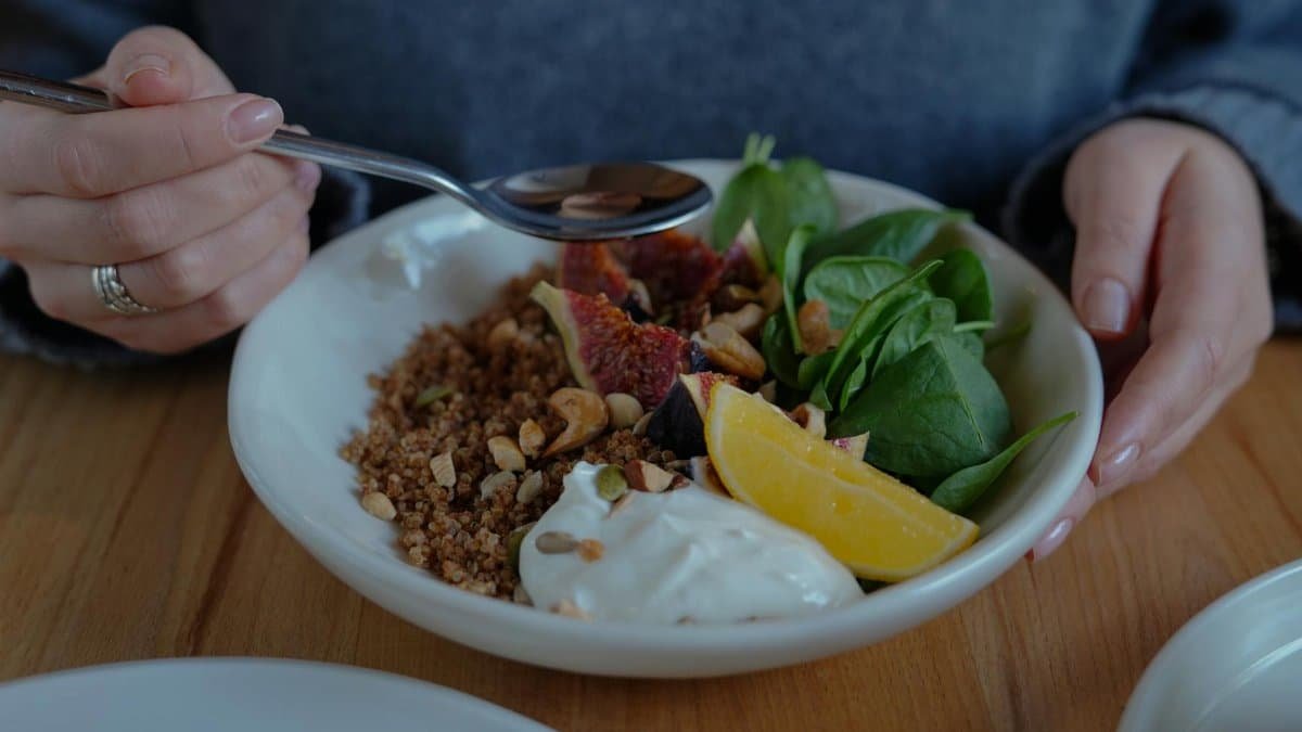 A vibrant brunch bowl with fruit, greens, and nuts for a nutritious meal.