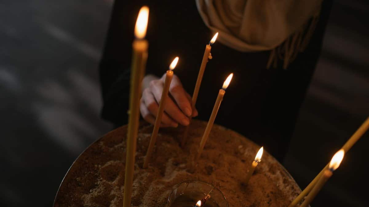 A serene scene of a hand lighting candles, symbolizing tranquility and reflection.