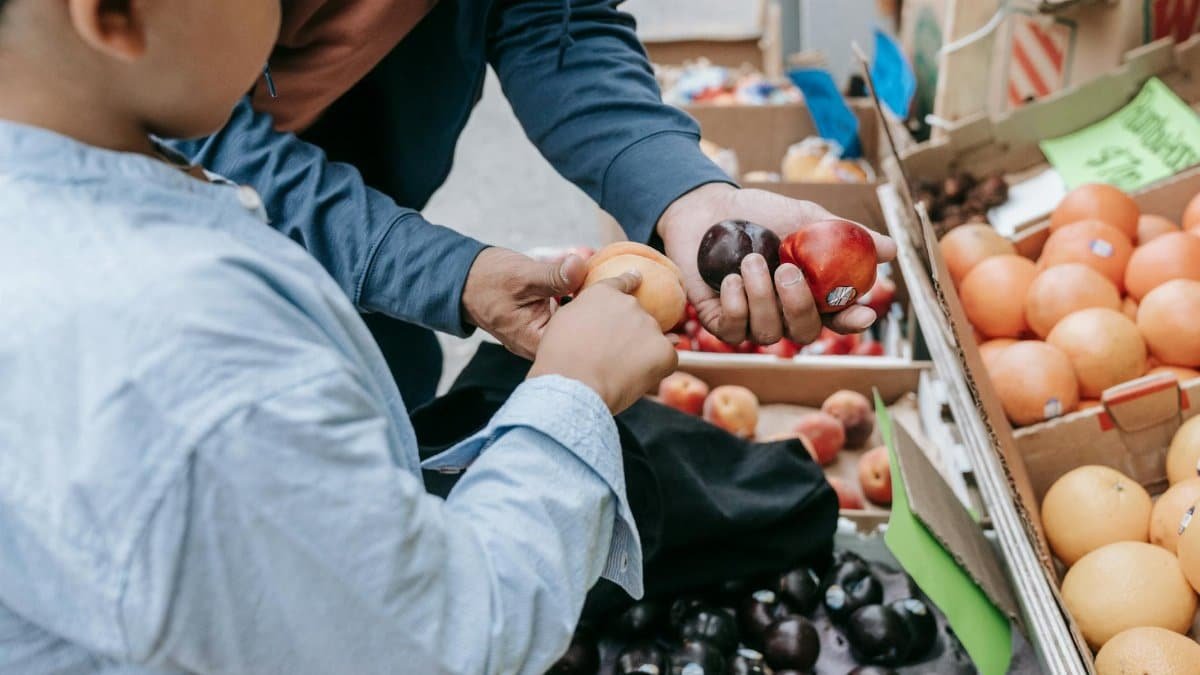 Father and son choosing fresh fruits together at a local market stand.