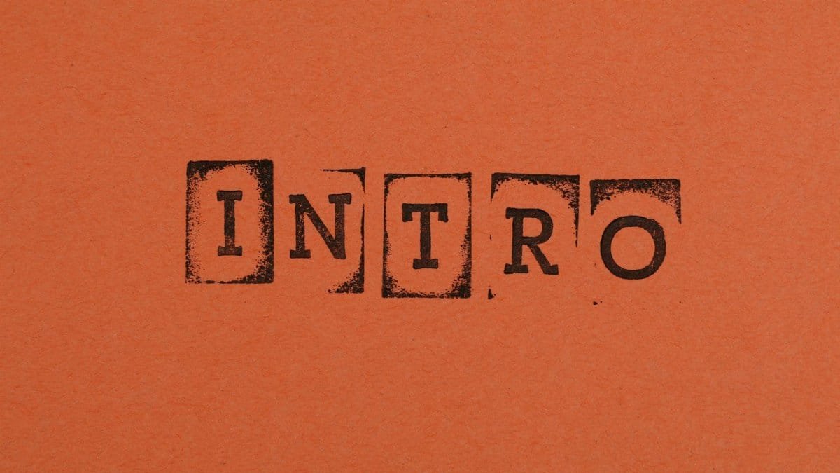 Close-up of the word INTRO stamped in black on an orange background, conveying a bold entrance.
