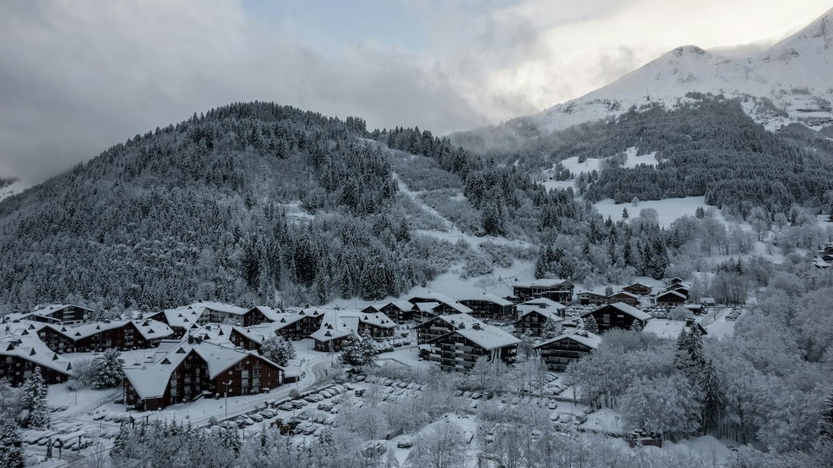 Charming snow-covered village nestled in the stunning French Alps landscape, ideal for winter travel inspiration.