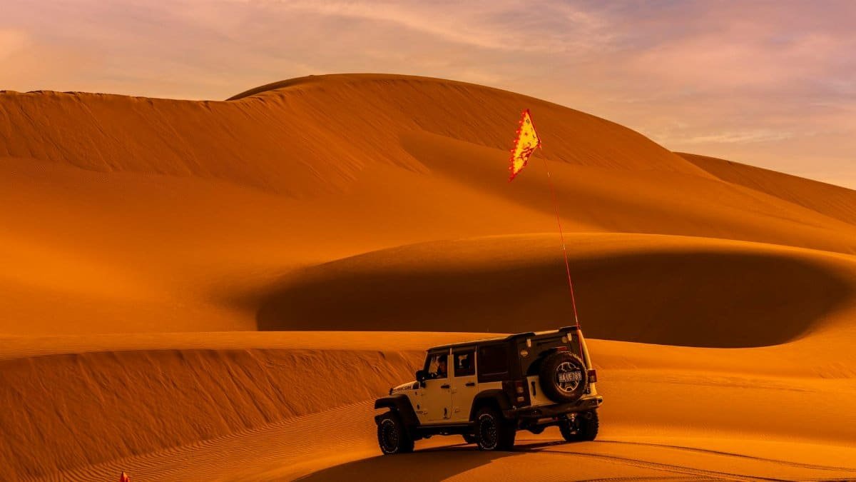 A thrilling SUV adventure in stunning desert sand dunes under the warm sunset light.
