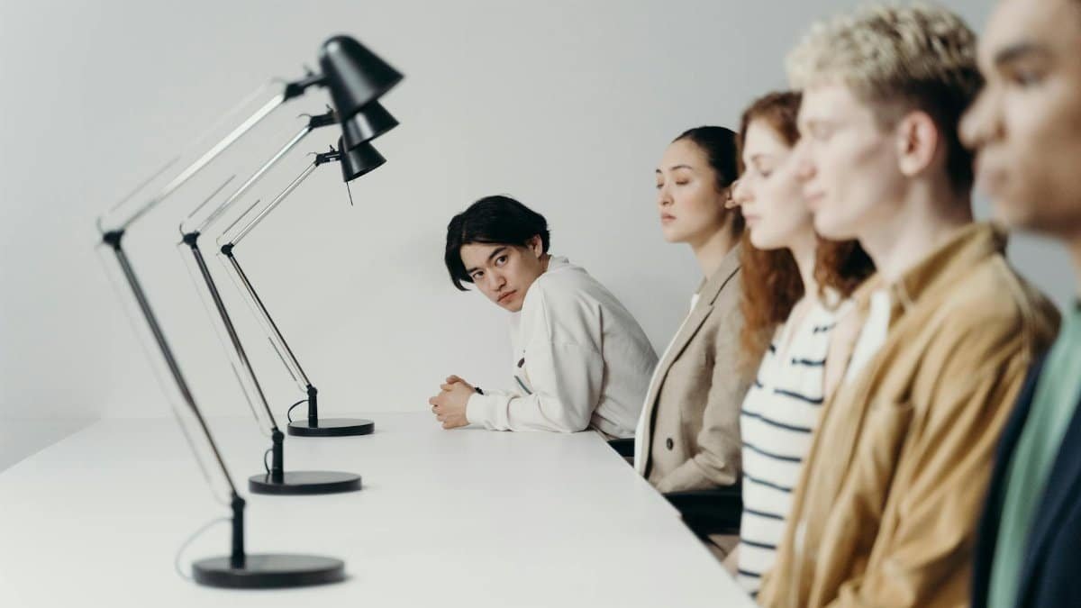 Group of professionals engaged in a focused office meeting setting under modern lamps.