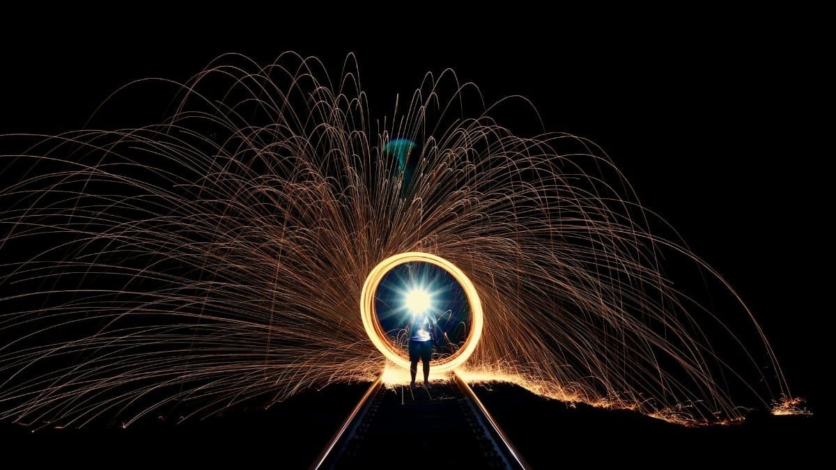 A mesmerizing display of sparks and light along railroad tracks at night, showcasing artistic long exposure photography.
