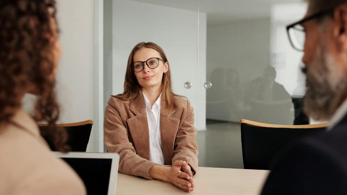 Young woman attending a job interview in a modern office, showcasing confidence and professionalism.