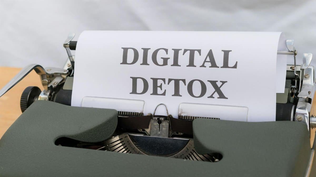Close-up of a typewriter with paper showing 'Digital Detox', emphasizing a tech-free lifestyle.