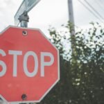 A red stop sign on a pole against a blue sky with light clouds. Outdoor scene.