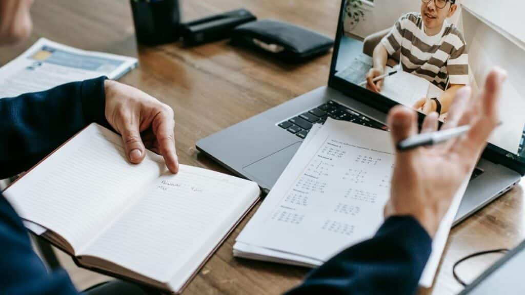 A professional conducting an online class through a video call with a student.