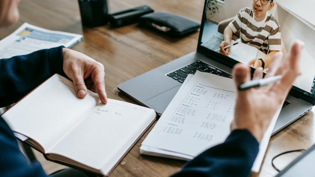 A professional conducting an online class through a video call with a student.