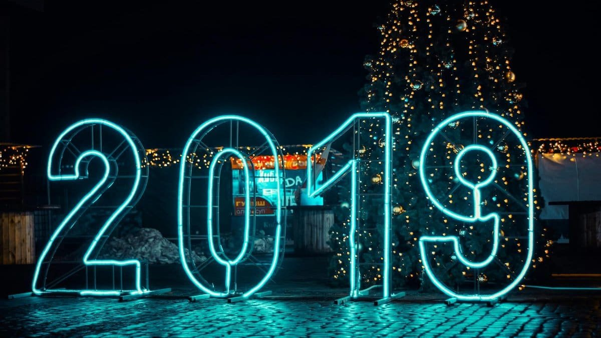 Bright neon '2019' sign with Christmas tree, perfect for New Year's festivities.