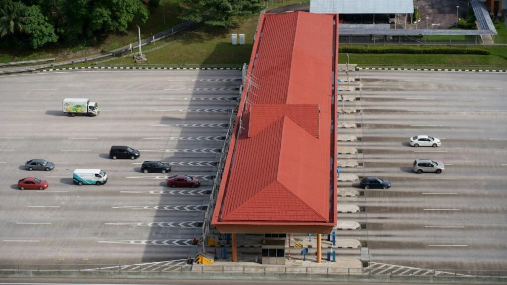 High angle aerial shot of a toll plaza with cars and trucks on an expansive highway.