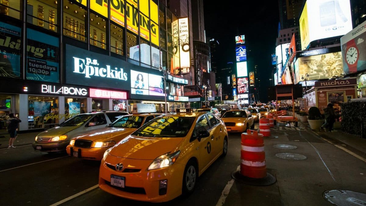 Dynamic night view of Times Square with busy traffic and bright billboards in New York City.