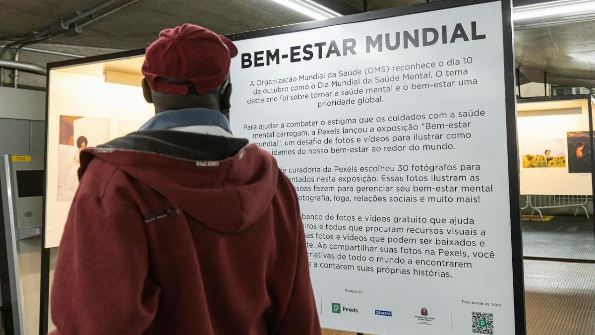 A person reads about global mental health awareness at a photo exhibition.