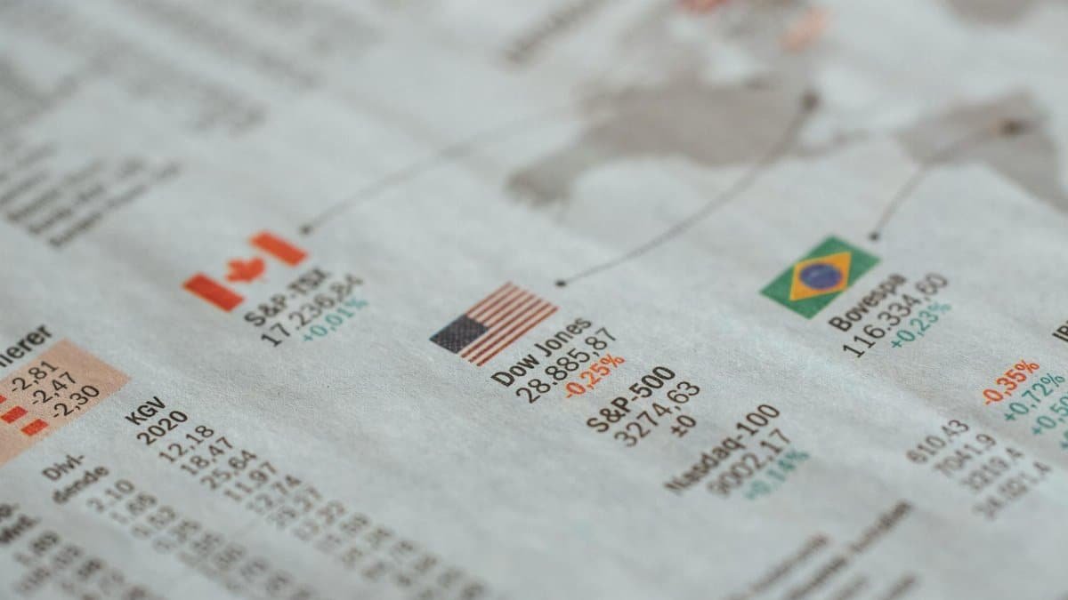 Detailed close-up of a newspaper displaying global financial market statistics and country flags.