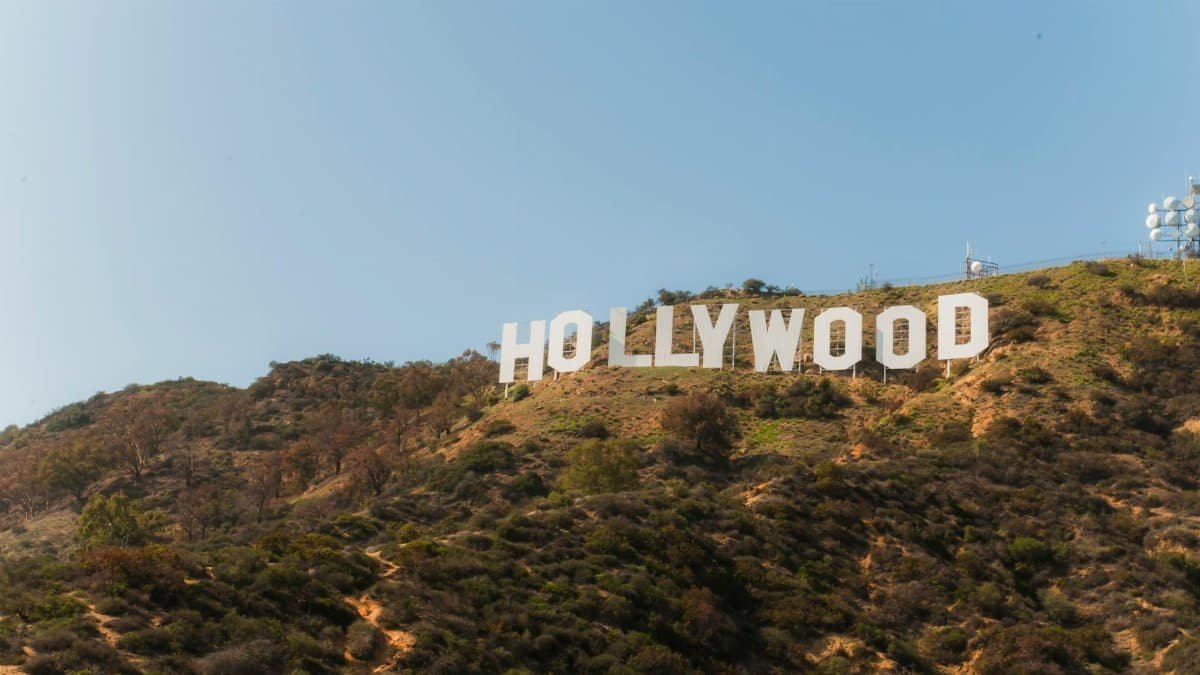 Famous Hollywood Sign on hillside under clear blue sky in Los Angeles, California.