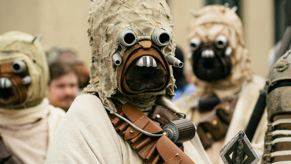 A group of people in detailed Star Wars cosplay costumes attending an outdoor event.