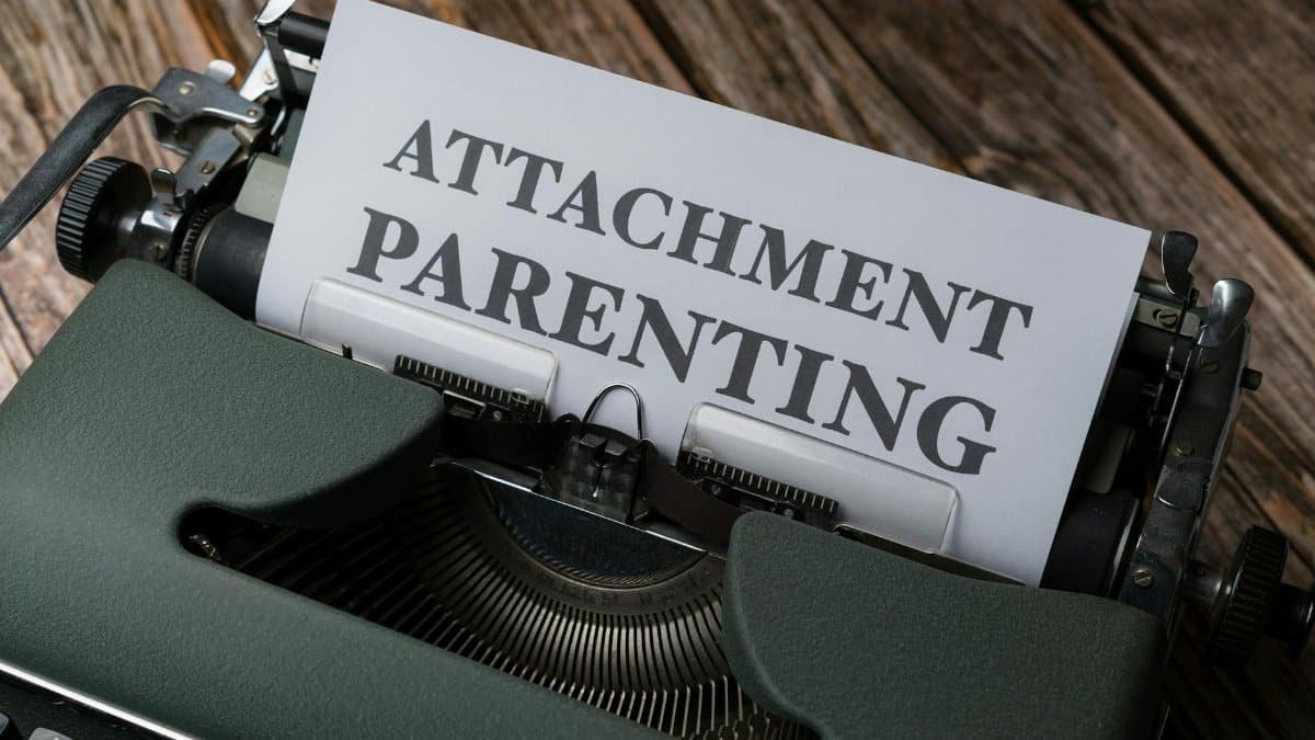 Top view of typewriter with 'Attachment Parenting' typed paper, rustic wood background.