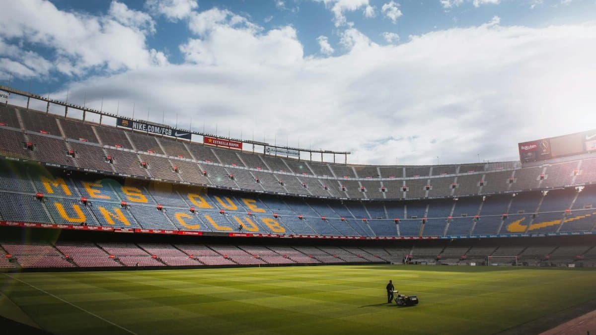 A vibrant football stadium with a well-maintained grass field under a bright sky, showcasing its iconic architecture.