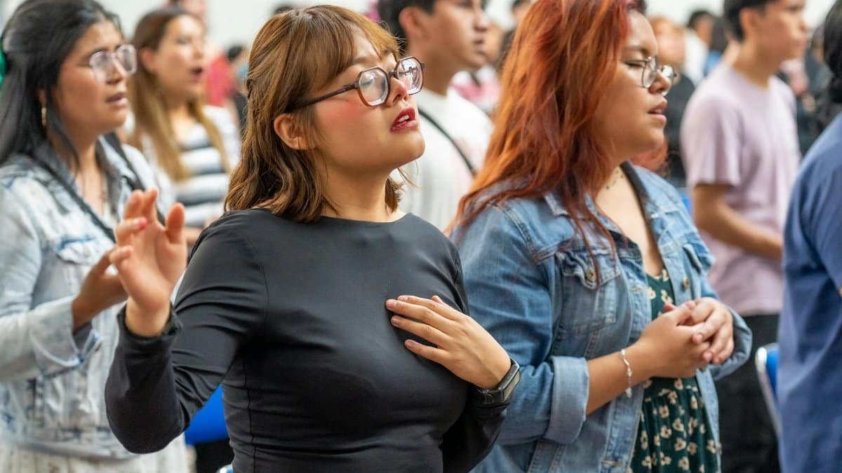 A diverse group of people engaged in passionate worship in Ciudad de México.