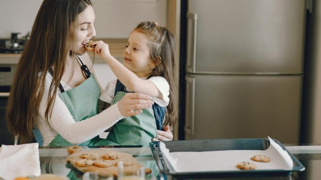 A joyful moment of a mother and daughter baking cookies together in the kitchen.