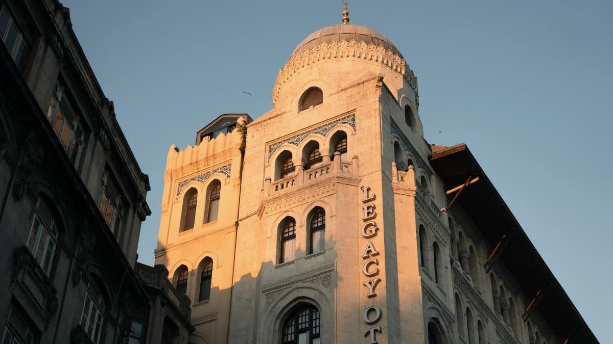 Ottoman architecture of Legacy Ottoman Hotel highlighted by golden sunset light, showcasing historical design elements.