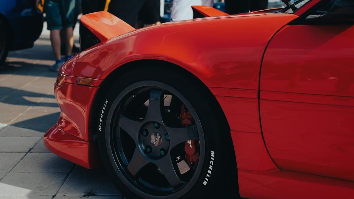 Close-up of a stylish red sports car on display at a car show.