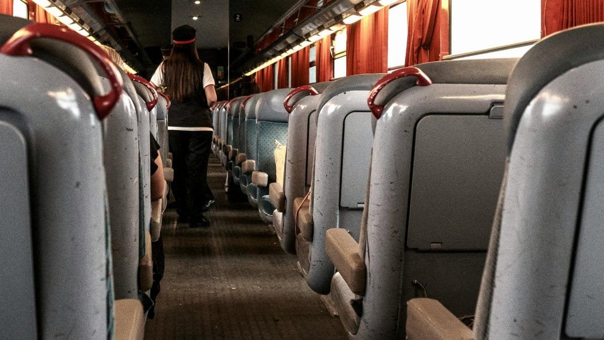 A view of a train interior in France showcasing red curtains and passengers onboard.