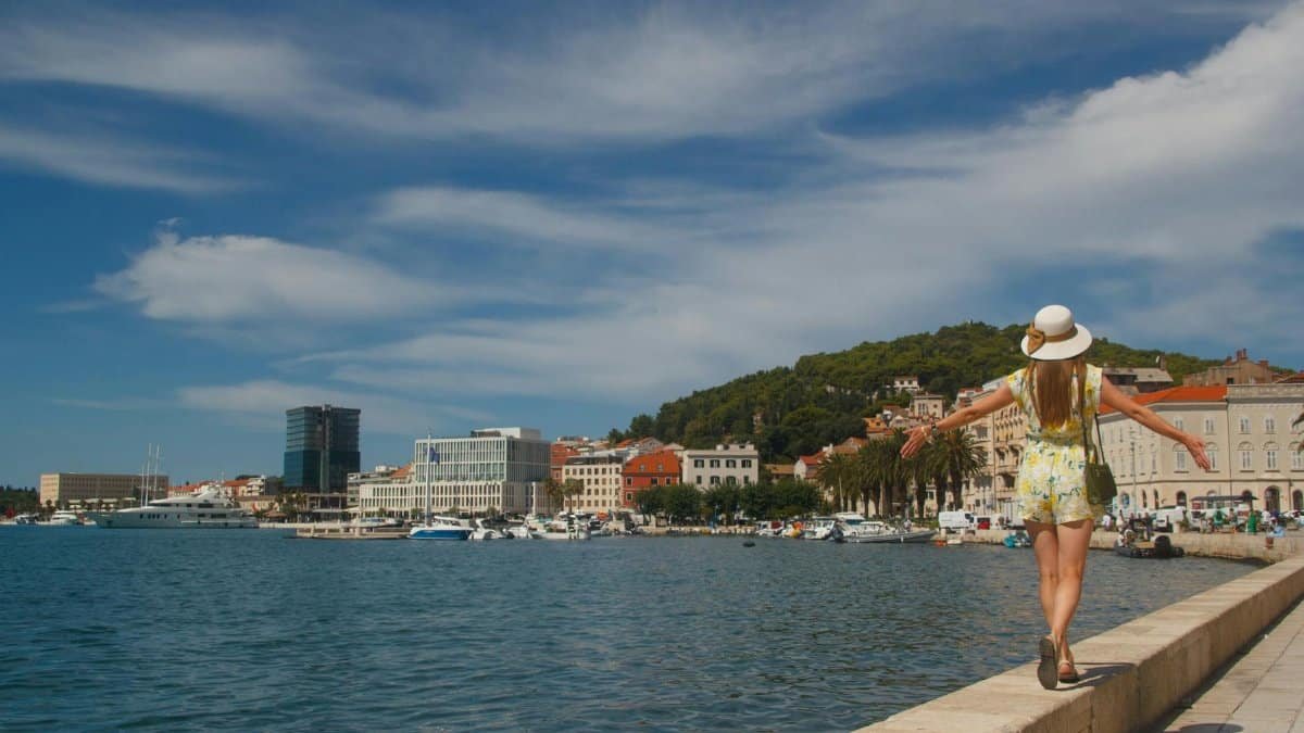A tourist walks along the scenic waterfront promenade in Split, Croatia.