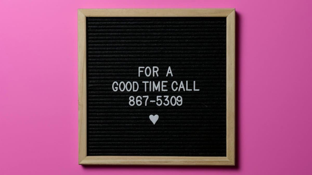 Wooden letter board with playful message against a pink background.