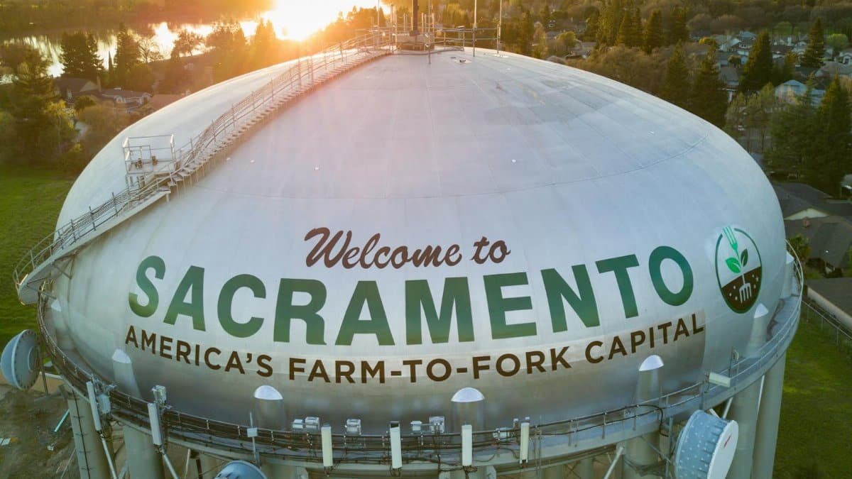 Aerial view of Sacramento water tower with scenic sunset in the background.