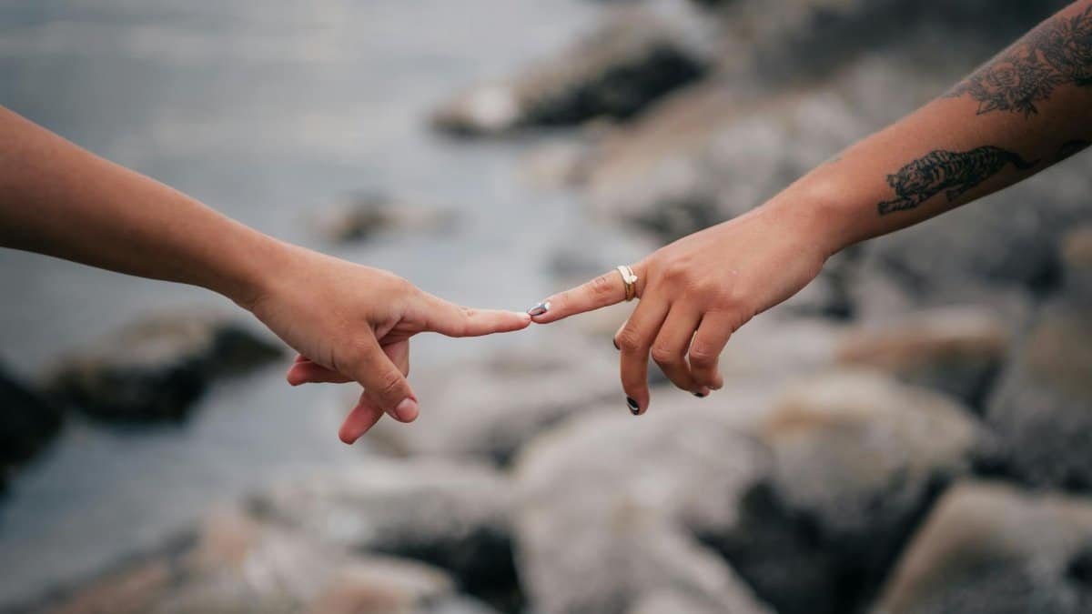 A close-up of two hands reaching out and almost touching, symbolizing connection.
