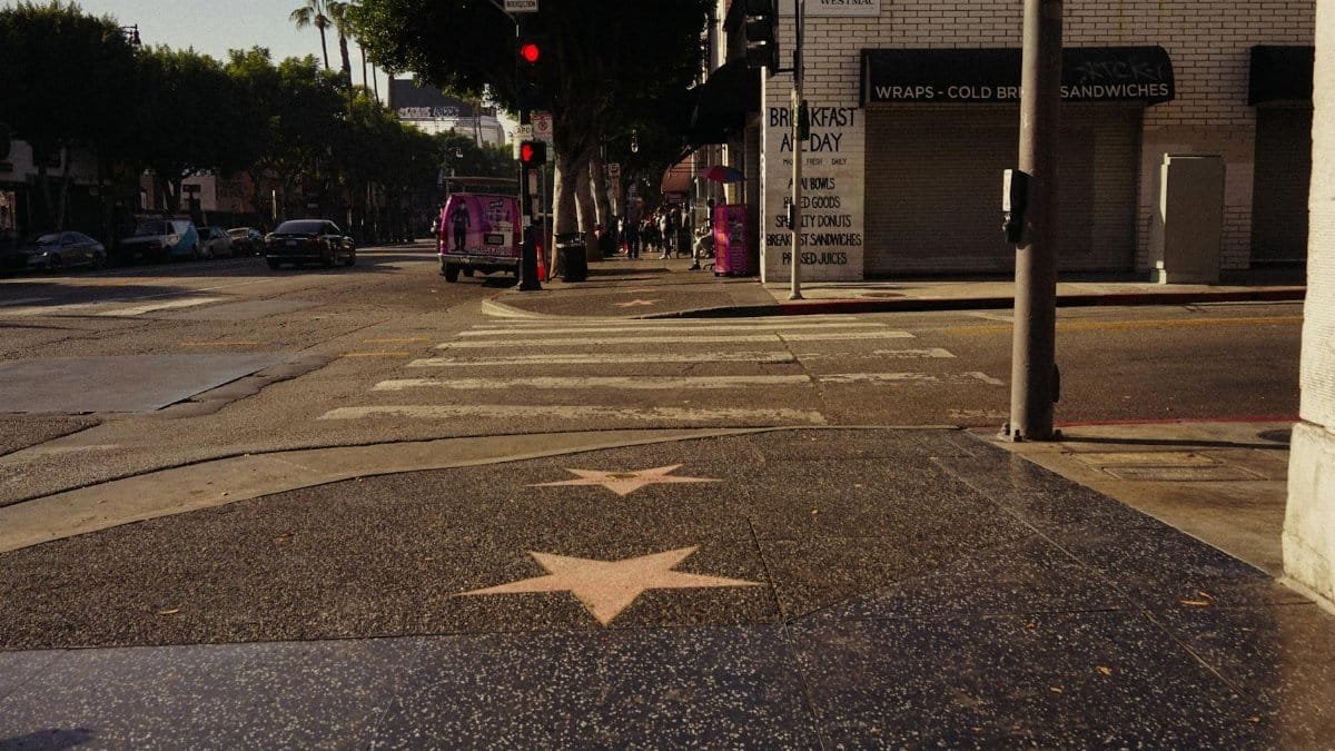 View of Hollywood Boulevard with Walk of Fame stars and city hustle in daylight.