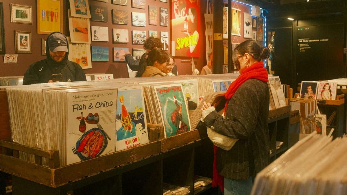 A bustling scene of customers browsing vinyl records in a cozy London store.