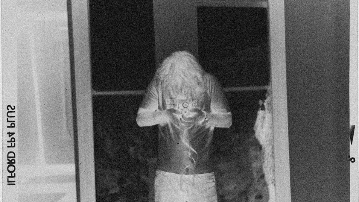 Retro negative film of a person taking a mirror selfie.