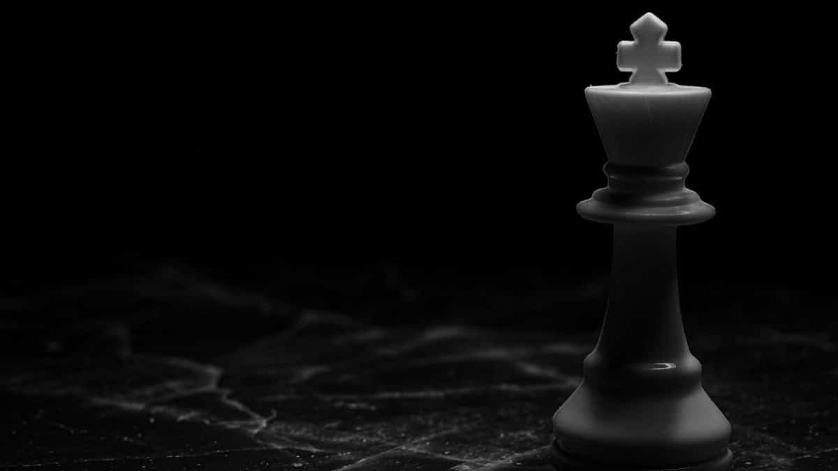 Striking image of a white chess king on a dark marble surface, symbolizing strategy and power.