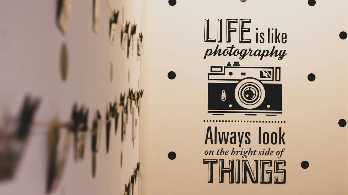 Wall art with a photography-themed inspirational quote and vintage camera graphic.