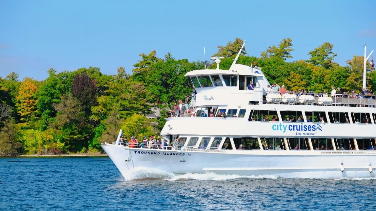 Enjoy a scenic river cruise aboard the Thousand Islander IV amidst lush green landscapes.