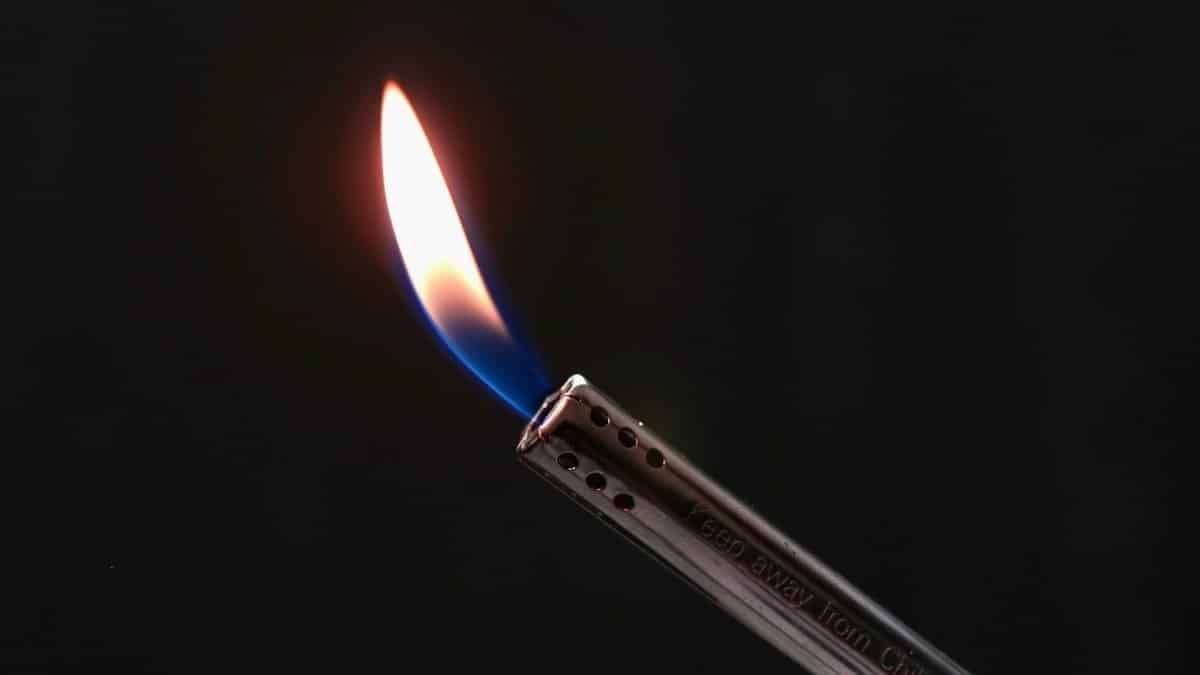 Detailed image of a blowtorch flame with a black background, highlighting the fire's blue and orange hues.