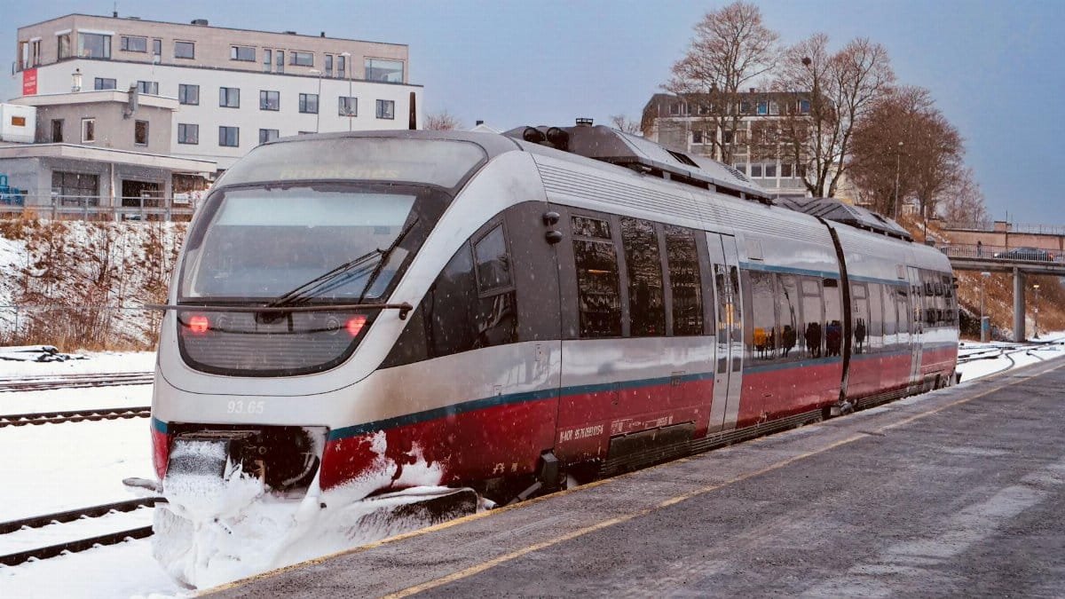 Modern train departs Åndalsnes station in winter's snow, Møre og Romsdal, Norway.