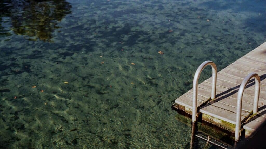A tranquil scene at Wekiwa Springs featuring a wooden dock and crystal-clear waters, perfect for summer relaxation.