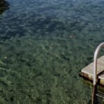 A tranquil scene at Wekiwa Springs featuring a wooden dock and crystal-clear waters, perfect for summer relaxation.
