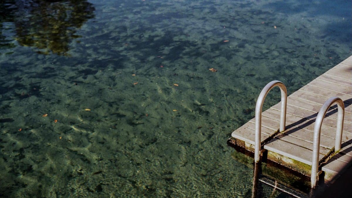 A tranquil scene at Wekiwa Springs featuring a wooden dock and crystal-clear waters, perfect for summer relaxation.