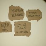 Cardboard signs convey job loss and economic crisis message, ideal for articles on unemployment.