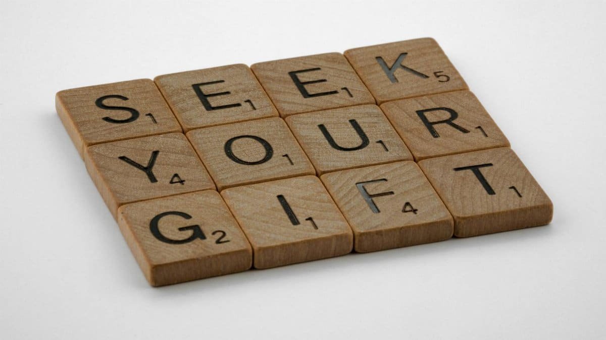 Scrabble tiles spelling out 'Seek Your Gift', highlighting creativity and inspiration.