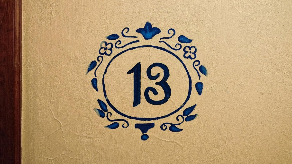 Artistic number 13 painted on a textured wall with blue floral design, Naolinco, Mexico.